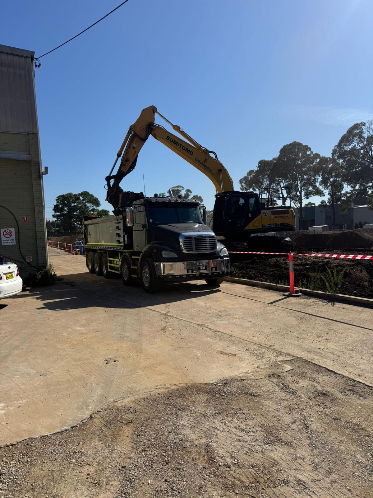 Excavator loading a tipper at dawn
